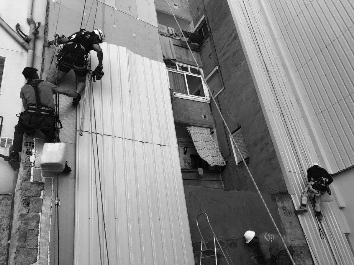 Imagen en blanco y negro de trabajadores de Imdeba realizando trabajos verticales